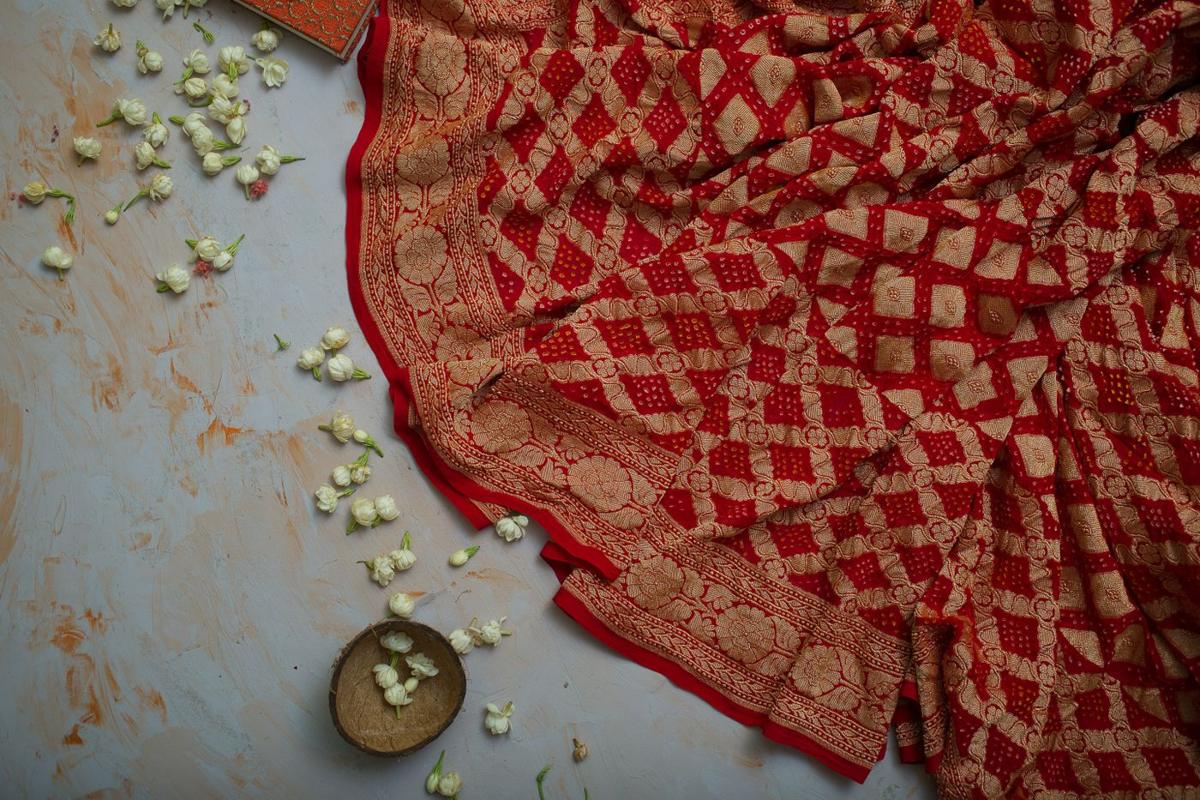 Red silk with woven gold zari and a gold coin