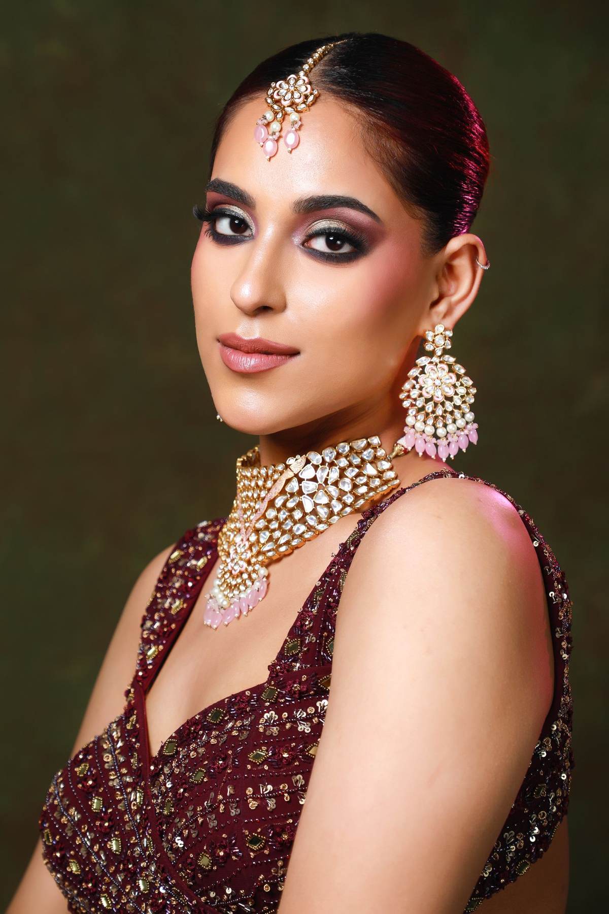 Model in a maroon sequinned couture blouse with a kundan choker and statement earrings